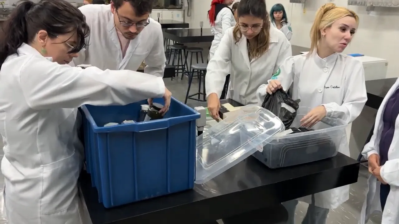 vários estudantes de jaleco organizando e separando resíduos em caixas plásticas
